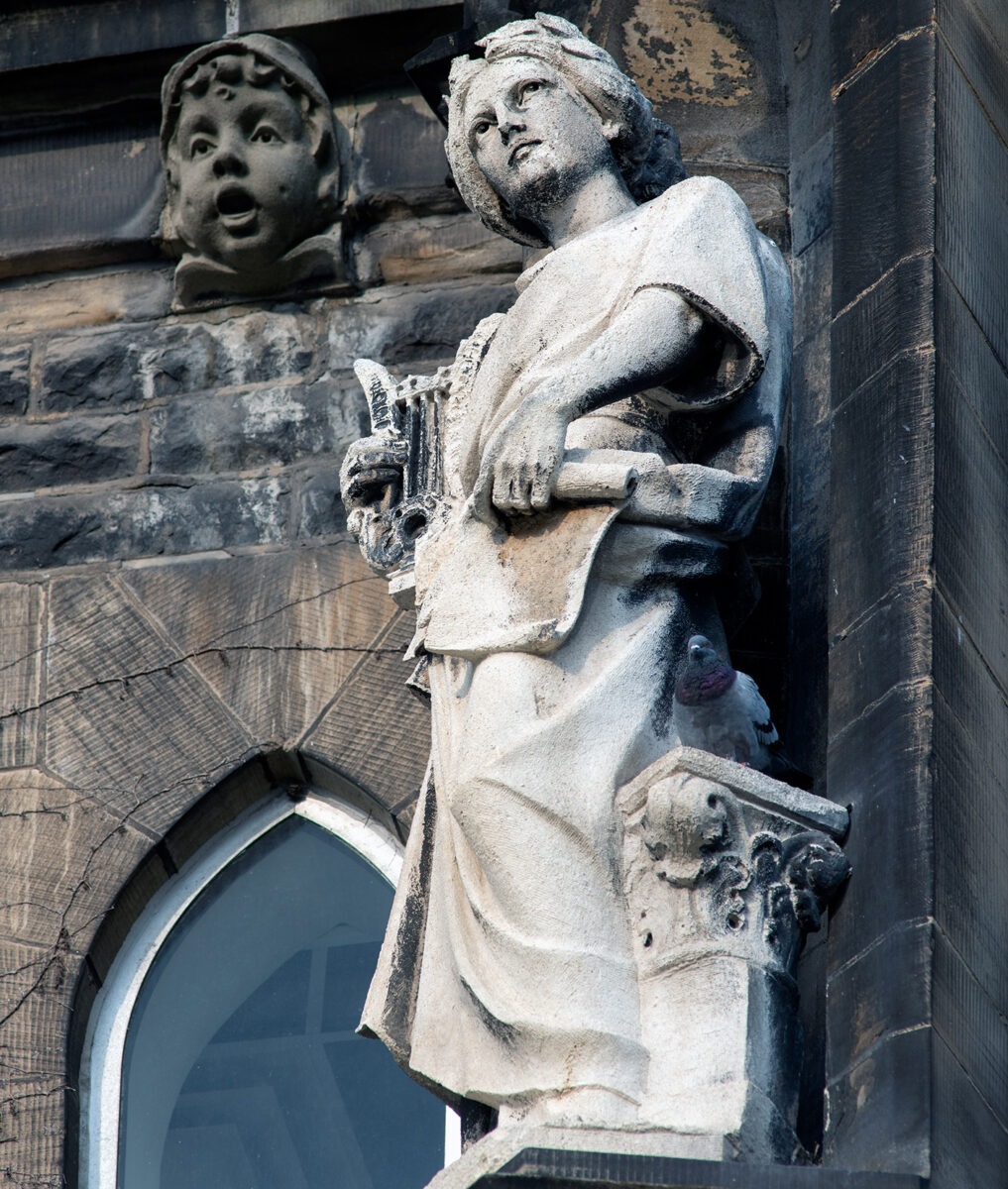 A statue on the school of Saint Michaels representing the old morality versus the new morality that of political correctness.