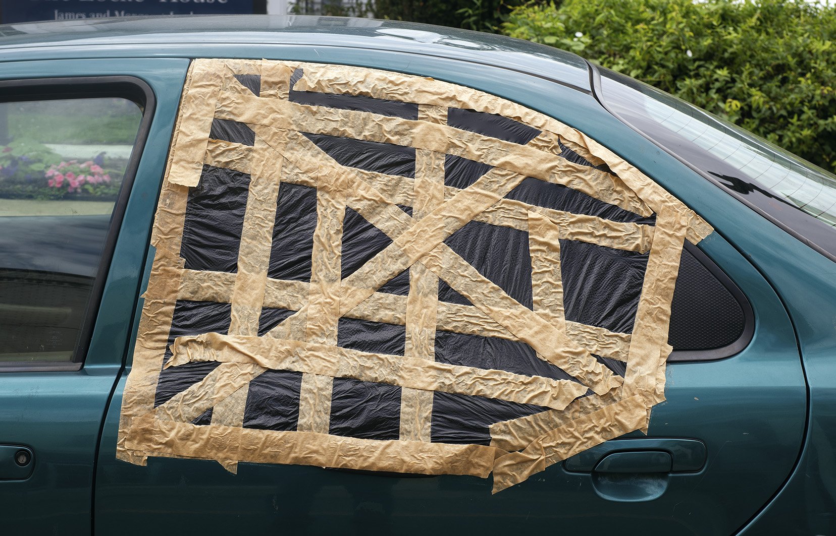A car window is sealed with an unusual amount of tape, East Liverpool
